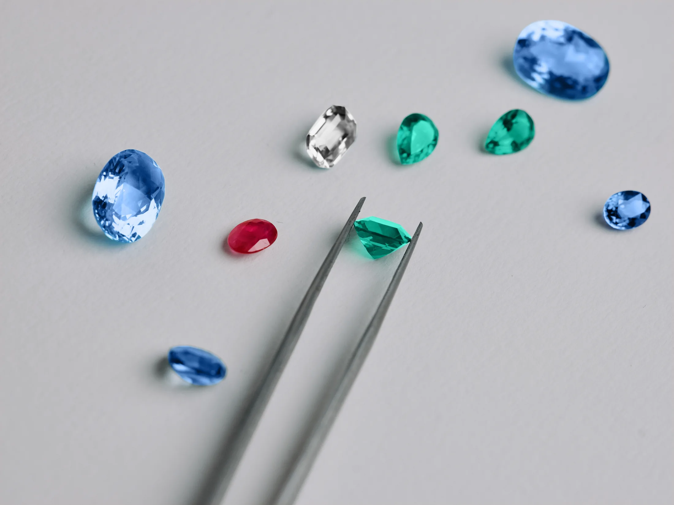 Pierres colorées et pince à bijoux sur la table